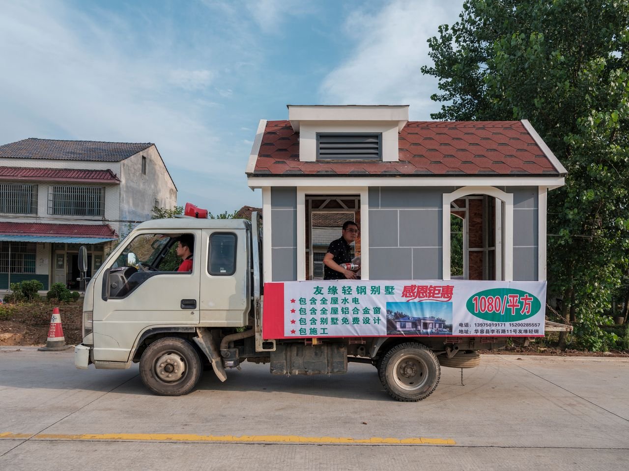 Services A unique truck carrying a miniature house, promoting innovative construction.
