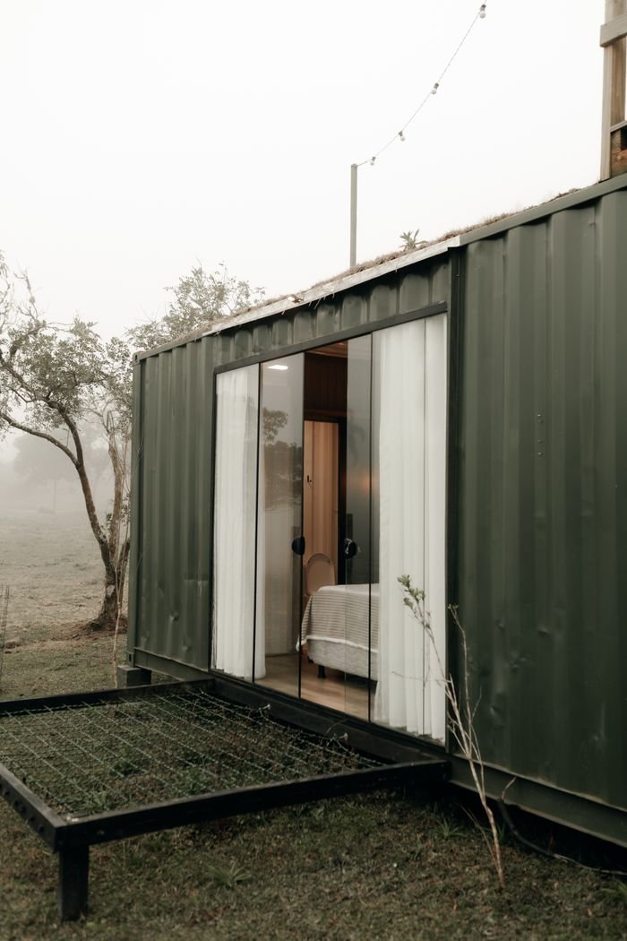 Services Contemporary container home with open sliding doors on a foggy day.
