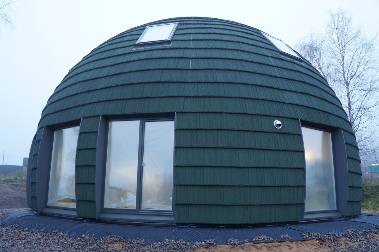 Services Unique green dome house on a foggy day, showcasing contemporary architecture.