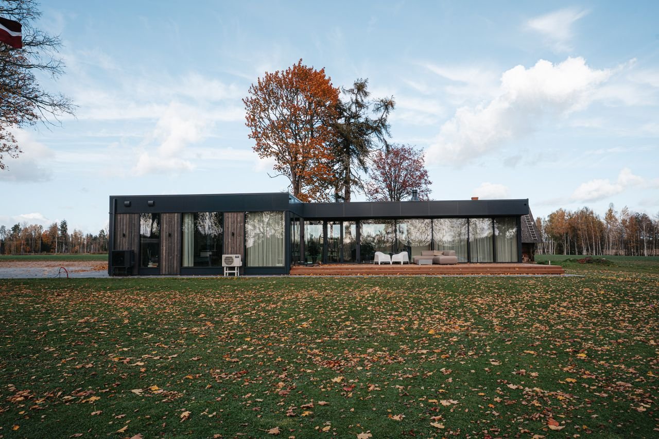 Services A sleek modern house surrounded by fall foliage in a rural setting.
